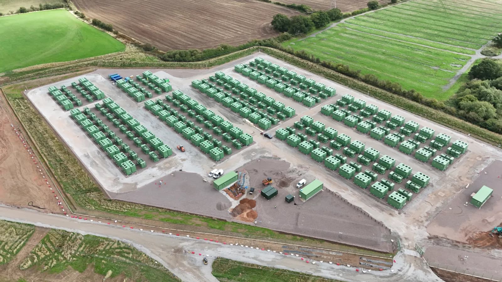 Aerial view of BW ESS's Hams Hall battery energy storage site in the West Midlands, England, with rows of green battery containers
