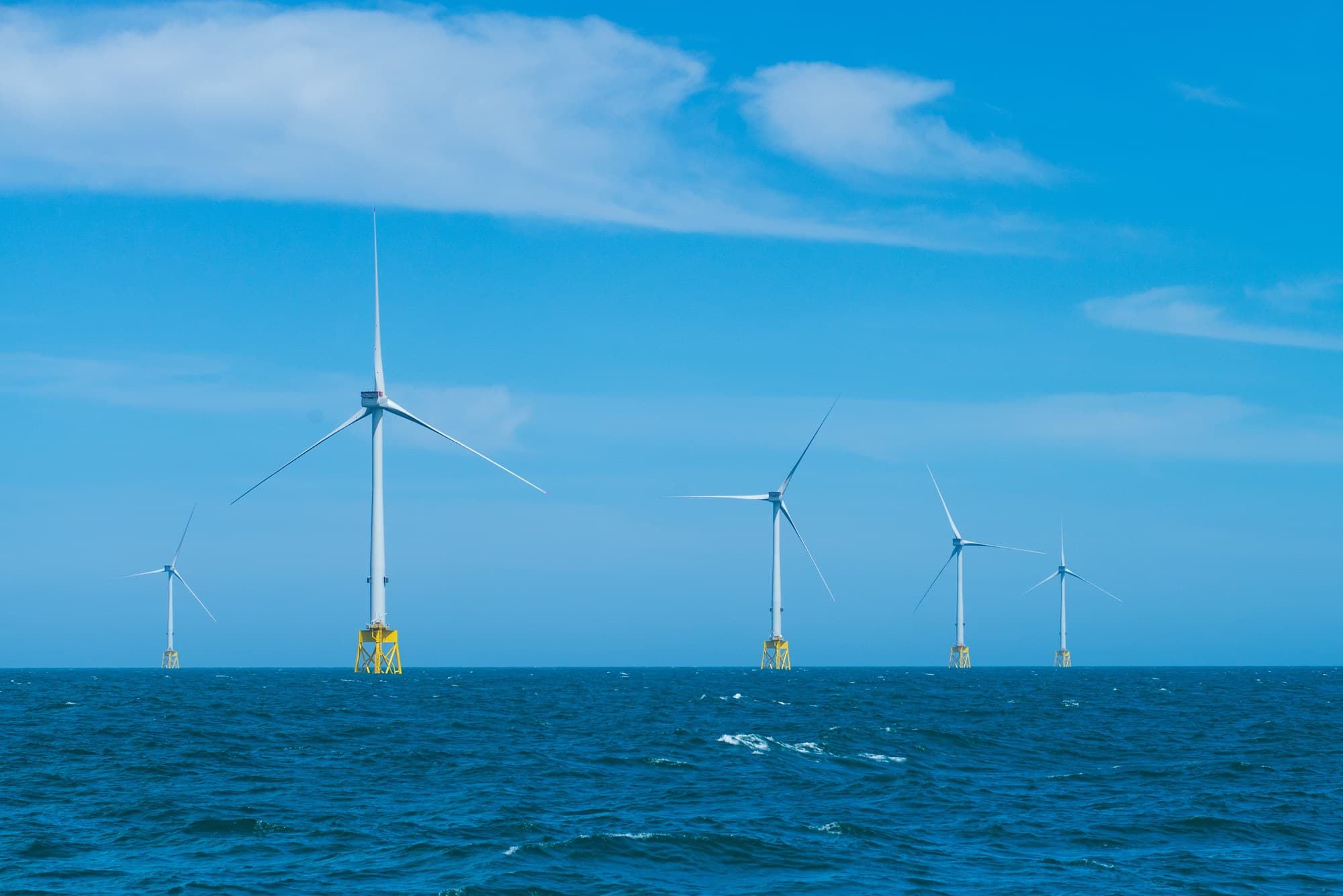 Offshore wind turbines on yellow foundations at sea, from the Outer Dowsing consent announcement